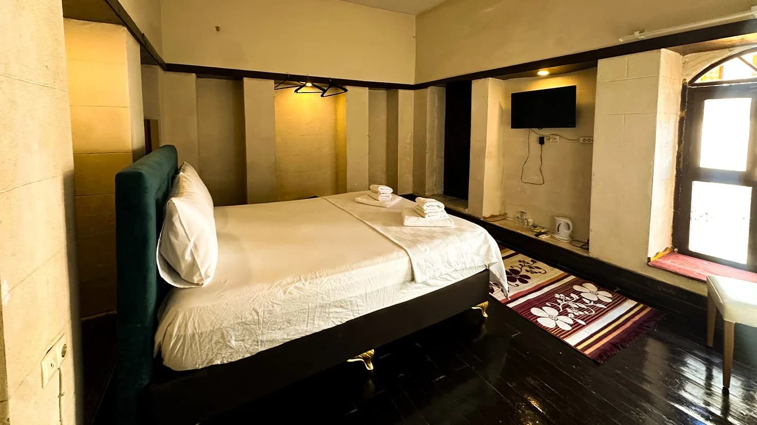 Window, TV and bed in the Stone Niche Room