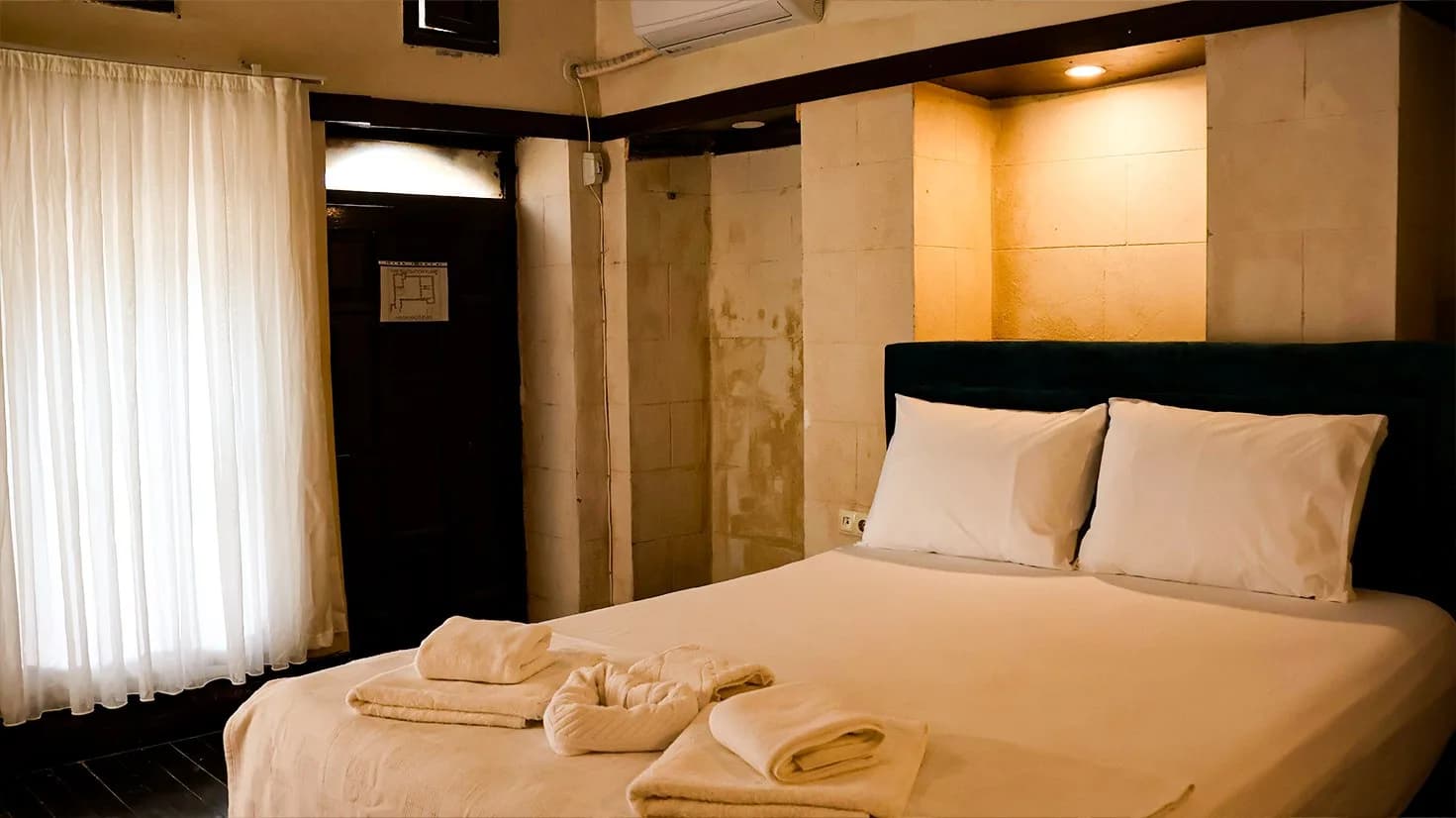 Double bed made up with towels in the Stone Niche Room