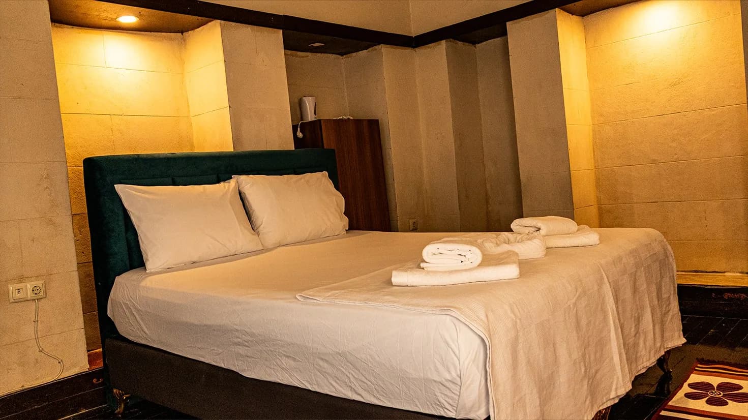 Bed with velvet headboard in the Stone Niche Room